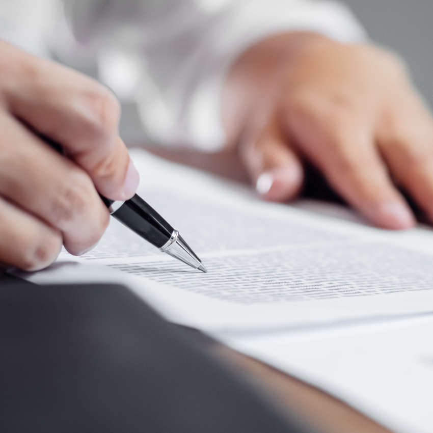 Image of a doctors hand holding a pen and signing a document