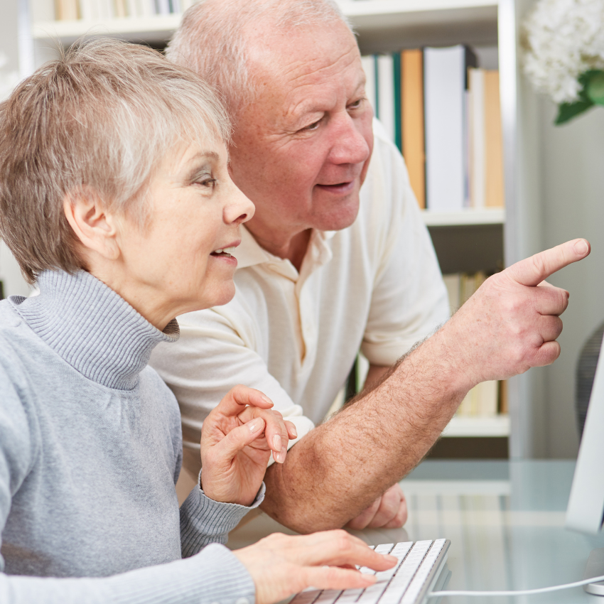 Image of an elderly couple pointing at a computer screen